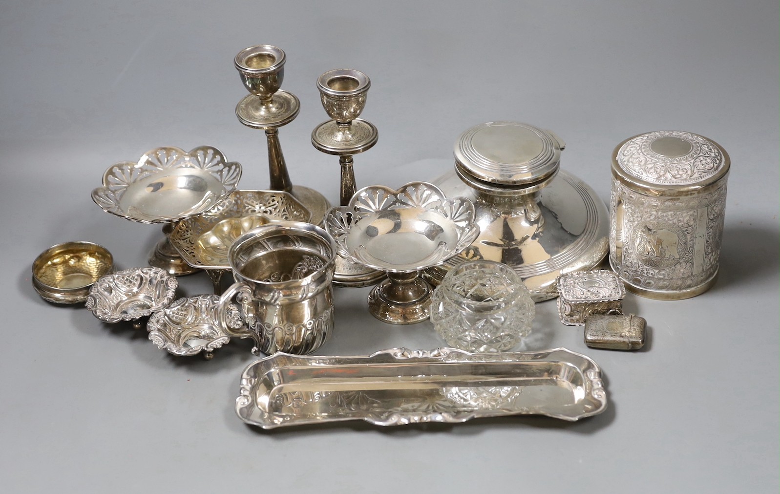 Assorted silver including a capstan inkwell, pair of dwarf candlesticks, pair of pedestal nut dishes, one other dish, christening mug, pin tray, five other items and an Indian white metal canister and cover.